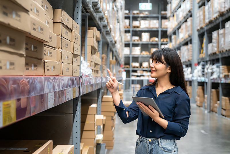 Picture of a woman in a warehouse reviewing inventory