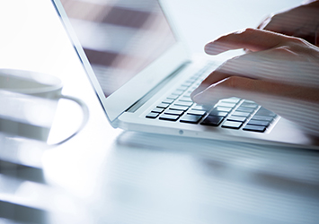 Close up of hands typing on a laptop